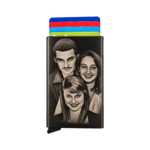 Porte-cartes personnalisé en métal noir, recto gravé d'un portrait de trois personnes, cartes colorées visibles, fond blanc