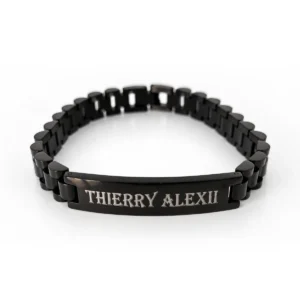 Gourmette noire personnalisée en acier inoxydable, plaque gravée « Thierry Alexii », posée sur fond blanc